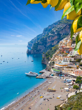 Picturesque Positano on Amalfi Coast, Italy, with colorful houses on cliffs and clear blue waters of Mediterranean sea. Vibrant ripe yellow lemons in foreground. Welcome to Positano!