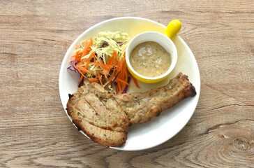 grilled Kurobuta chop pork steak with and salad dipping sauce on plate