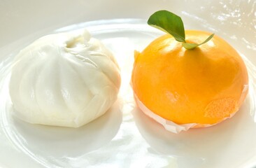 Chinese steamed bun stuffed sweet orange and salty chop pork on plate