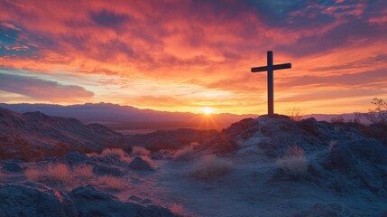 Sunset over desert landscape with silhouette of cross and dramatic sky