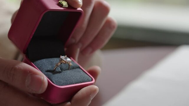 Close-up of hands opening a red box for a wedding ring and jewelry. Valentine's Day and marriage proposal. Generative AI