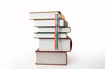 Close up of books with LGBTQ rainbow flag on white background