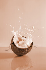 Cracked coconut and splashes of coconut milk on a blue background.