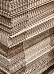 Stacked sheets of cardboard ready for packaging and shipping in a warehouse