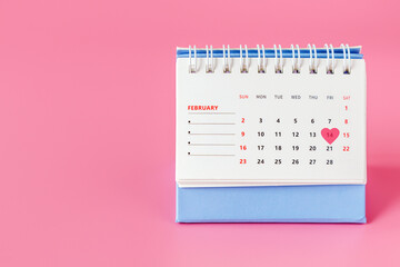valentine's day. A desktop calendar with an open page for February and a date of February 14th in the form of a pink heart.