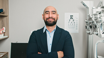 Smiling Male Optometrist Poses in His Professional Office Surroundings