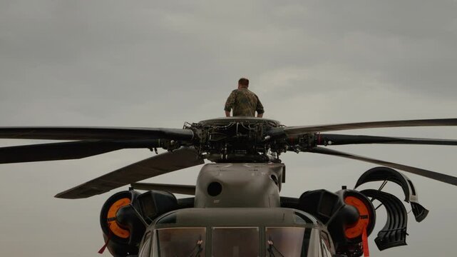 German Army Sikorsky CH-53GS helicopter participates at Bucharest Air Show, (BIAS) 2024. A pilot sits on the helicopter propellers and watches the show.