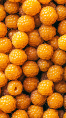 Fototapeta premium A lot of yellow raspberries, closeup, healthy food, background, vertical illustration