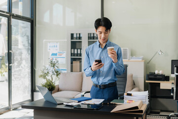 Businessman using mobile phone play social and enjoys a coffee.