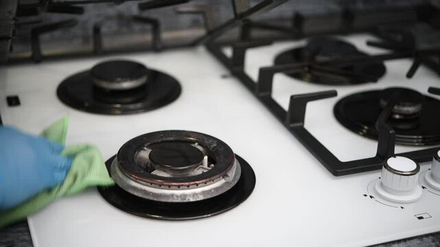 The housewife cleans the gas hob in the kitchen.. Housekeeping concept.