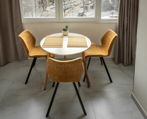 Dining table and three yellow chairs, modern home interior, round dining table set