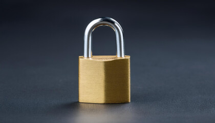 Naklejka premium Golden padlock on dark backdrop. Security, safety and protection concept.