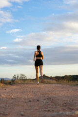 Girl running on the mountain at sunset. Copy space.