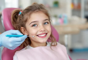 Young girl smiling brightly while receiving dental care in a modern clinic, showing a healthy attitude towards oral hygiene and dental visits