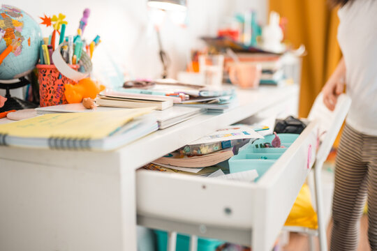 Mess in a desk drawer. Table organization concept. House cleaning themed photo.