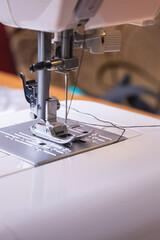 A CloseUp of a Sewing Machine Demonstrating the Threading and Stitching Setup Process