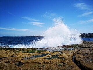 Ocean wave crashing on rocky shores