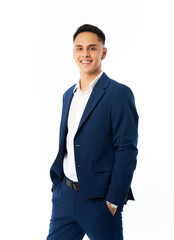 Young businessman smiling with hands in pockets in studio portrait