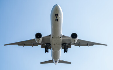 A commercial airplane flying overhead with detailed wings and powerful engines, soaring against a...