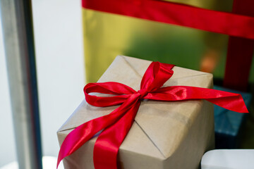 A beautiful gift wrapped in brown paper with a red ribbon