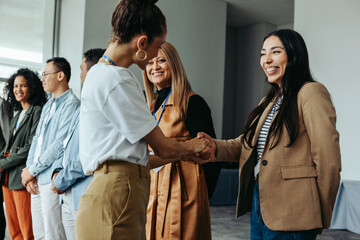 Diverse group of professionals networking and shaking hands at a business meeting