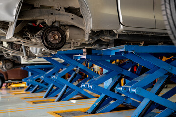 Car disc brake system and suspension maintenance during tire replacement at a garage workshop....