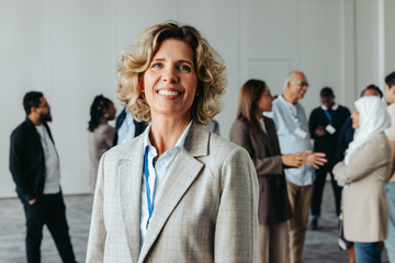 Confident mature businesswoman at networking event with successful professionals