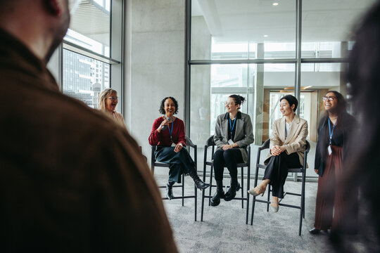 Businesswomen speaking at conference event, engaging in a professional discussion