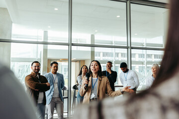 Confident businesswoman instructing group during workshop in bright modern office