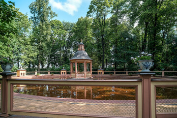 A pond with a gazebo in the summer garden of St. Petersburg in Russia.