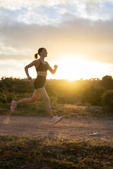 Girl running on the mountain at sunset. Copy space.