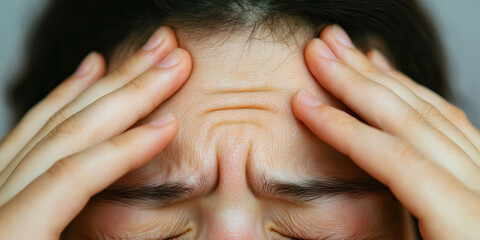 Fototapeta premium Close-up of Person's Forehead with Hands