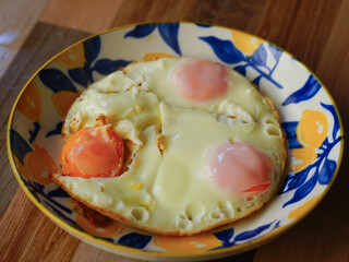Fried eggs on a plate on a wooden table. Close-up