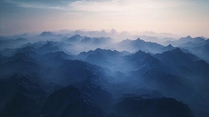 Majestic mountain ranges with layered blue ridges and a misty atmosphere, capturing the serene beauty of towering peaks and natural landscapes in the early morning light