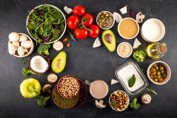 Plant based keto food background with low carb vegan keto diet ingredients, healthy vegetarian fat and protein source. Assortment green vegetables, nuts, legumes, oil, coconut, nuts, peanut butter