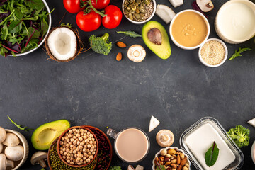Plant based keto food background with low carb vegan keto diet ingredients, healthy vegetarian fat and protein source. Assortment green vegetables, nuts, legumes, oil, coconut, nuts, peanut butter