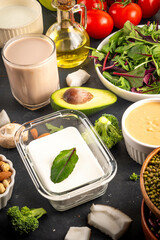 Plant based keto food background with low carb vegan keto diet ingredients, healthy vegetarian fat and protein source. Assortment green vegetables, nuts, legumes, oil, coconut, nuts, peanut butter