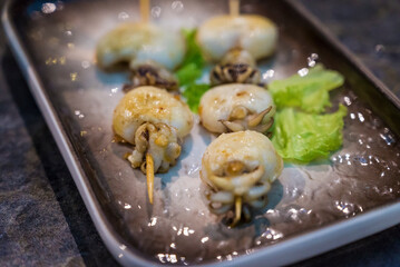 Squid in black plate  in Japanese sushi restaurant 