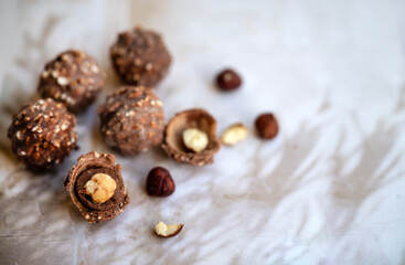 Chocolate candy with hazelnuts on shadows  background