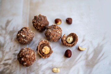 Chocolate candy with hazelnuts on shadows  background