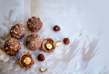 Chocolate candy with hazelnuts on shadows  background