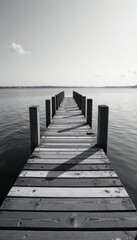 Fototapeta premium Striped monochrome bridge over calm water Black and white wood planks , journey, landscape