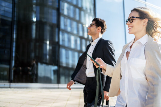 Business professionals walking confidently in an urban setting on a sunny day - Powered by Adobe