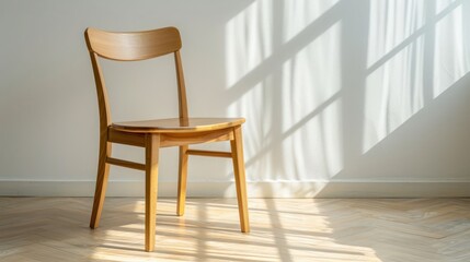 Sunlit wooden chair casting shadows in a minimalist room with soft fabric curtains