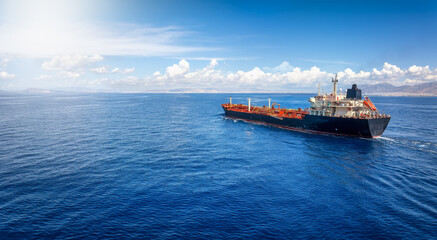 Rear view of a chemical goods or crude oil tanker sailing with speed over the blue Ocean with copy space