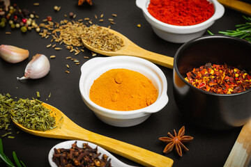 Dry spices in a wooden spoons close-up on a vintage background