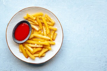 French fries with tomato sauce, overhead flat lay shot on a slate background, with a place for text