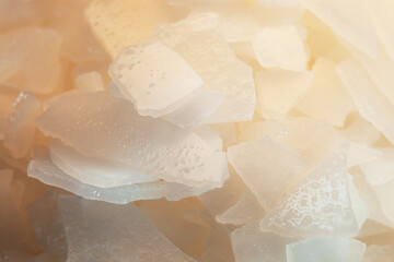 Bath salt. Close-Up pile of Magnesium Salt Flakes on grey concrete background, white particles sea...