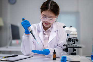 A woman in a lab coat is working with a pipette, likely conducting an experiment