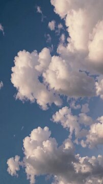 Soft clouds drift lazily across a calm blue sky, glowing warmly as they shift fluidly. The peaceful atmosphere evokes serenity, suspending time in a tranquil moment of quiet beauty.
